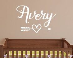 a baby crib with a wall decal that says,'avery'and an arrow