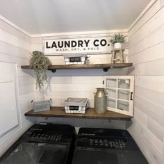 a washer and dryer in a small room with shelves on the wall above them