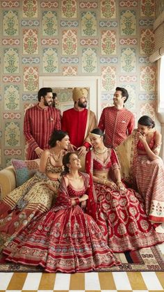 a group of people in red and gold outfits posing for a photo together on a checkered floor