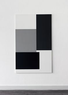 a white wall with black and grey squares on it