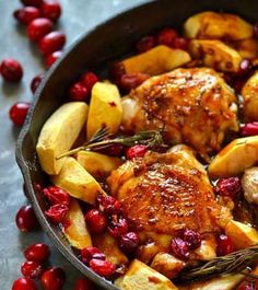 a pan filled with chicken, potatoes and cranberries