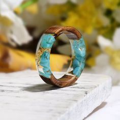 a wooden ring with blue flowers in the background