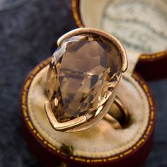 This vintage cocktail ring features a pear cut smoky quartz set with a partial bezel protecting the bottom and the tip of the stone. The ring was custom made in the 1970s, and we have left it unpolished to maintain its groovy patina. The ring is crafted in 14k yellow gold and is currently a size 4.5. Please note that there are tiny nicks and abrasions on the unprotected areas of the stone. Vintage Brown Ring With Polished Finish, Brown Large Stone Ring Jewelry, Smoky Quartz Gemstone Ring, Antique Engagement Rings Sapphire, Estate Jewelry Rings, Brown Smoky Quartz Gemstone Jewelry, Luxury Gold Smoky Quartz Jewelry, Smoky Quartz Jewelry, Vintage Cocktail Ring