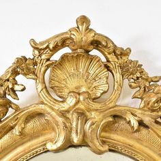 an ornate gold mirror is shown against a white wall