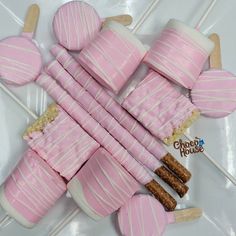 pink and white striped marshmallows arranged on top of each other with popsicle sticks