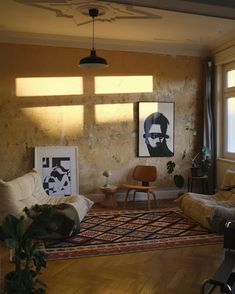 a living room filled with furniture and paintings on the wall