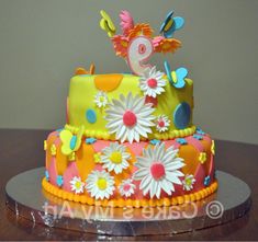 a colorful cake decorated with flowers and butterflies