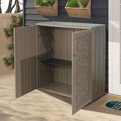 an open metal cabinet sitting on top of a wooden floor next to a blue wall