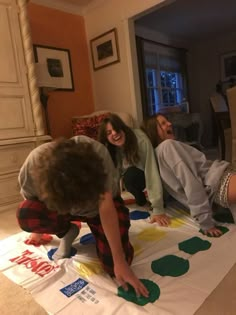 three people are doing crafts on the floor