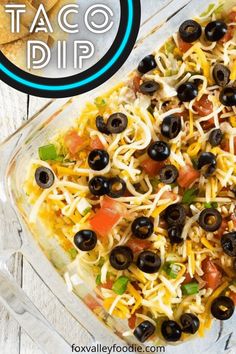 a casserole dish filled with black olives, cheese and tortilla chips