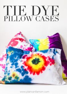 three colorful pillows sitting next to each other on top of a white surface with the same color as the pillow