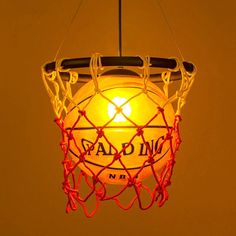 a basketball net hanging from the ceiling with an orange light in it's center