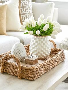 a wicker tray with flowers in it on a coffee table