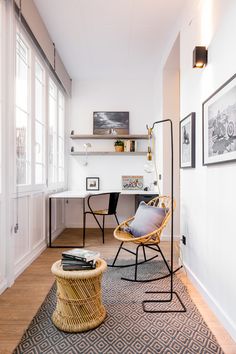 a living room filled with furniture next to a wall mounted book shelf and window sill