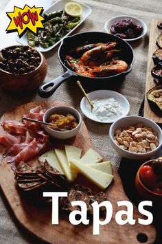 a table topped with lots of different types of meats and cheeses on top of wooden cutting boards