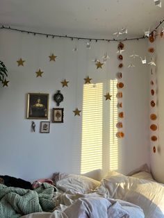 a bedroom with white walls and gold stars hanging from the ceiling