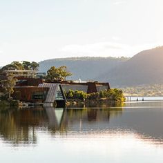 a large body of water surrounded by trees and buildings on top of the mountain range