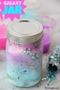 a jar filled with liquid and glitter next to some confetti