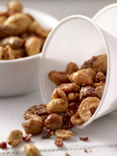 two white bowls filled with nuts on top of a table