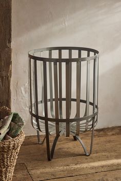 a basket sitting on top of a wooden floor next to a wall