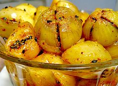 a glass bowl filled with cooked potatoes on top of a counter