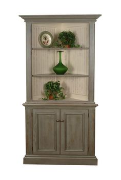 an old style china cabinet with potted plants on it's top and bottom shelf