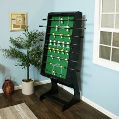 a foosball table in the corner of a room next to a potted plant