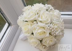 a bridal bouquet sitting on top of a window sill