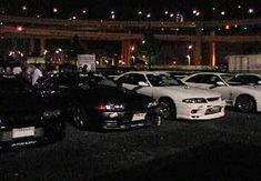 several cars parked in a parking lot at night