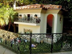 a white house with black wrought iron fence