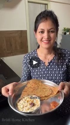 a woman holding a plate with food on it