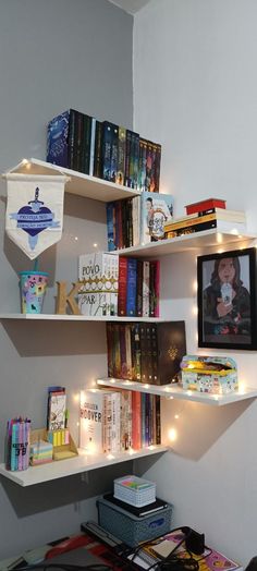 a bookshelf filled with lots of books next to a wall full of pictures