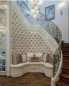 a couch sitting under a chandelier next to a stair case