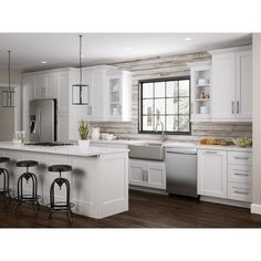 a large kitchen with white cabinets and wooden flooring, along with two bar stools