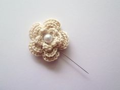 a crocheted flower with a pearl in the center