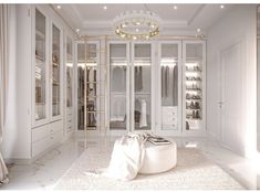 a walk in closet with white walls and flooring, chandelier hanging from the ceiling