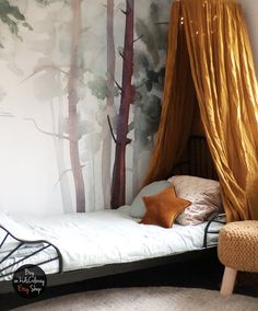 a bed with a canopy in front of a forest wall mural