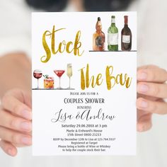 a woman holding up a sign with alcohol on it that says stock the bar couples shower