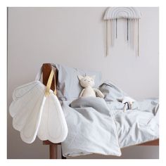 a bed with two fan shaped pillows on top of it and a stuffed animal next to it