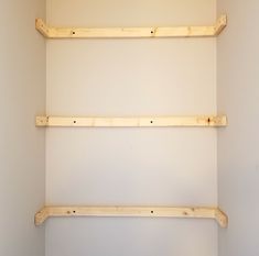 two wooden shelves in the corner of a room