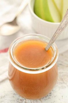 a glass jar filled with apple cider sitting on top of a table