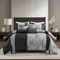 a bed with black and white comforters in a room