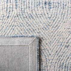 the corner of a rug with a blue and white design on it's surface