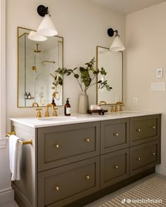 a bathroom with two sinks, mirrors and plants in vases on the counter top