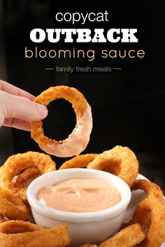 a plate with onion rings and dipping sauce on it that says copycat outback blooming sauce