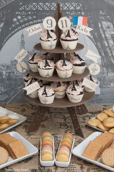 an assortment of desserts and pastries displayed in front of the eiffel tower