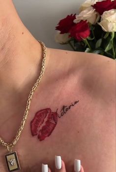 a close up of a person's chest with tattoos on it and flowers in the background