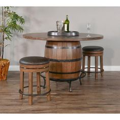 a wooden barrel table with stools around it