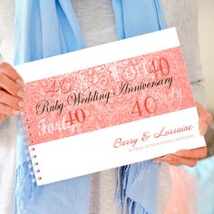 a woman holding up a pink wedding anniversary card with the date forty and forty on it