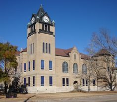 a large building with a clock on the top of it's tower and windows